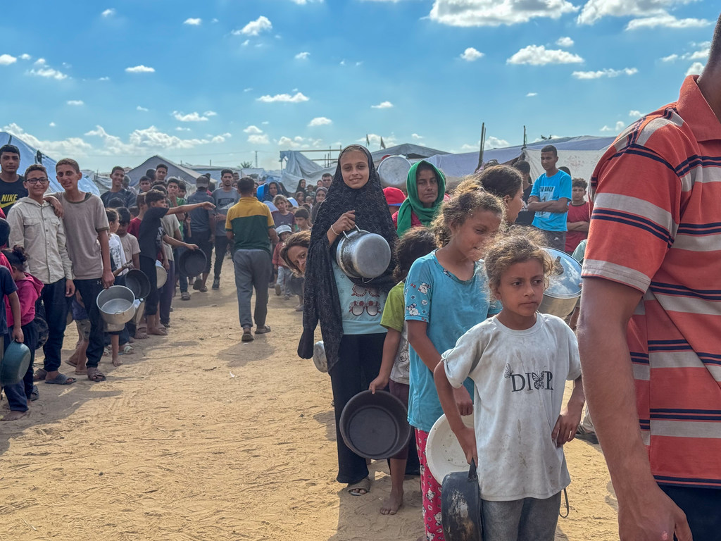 Les Gazaouis font la queue pour obtenir de la nourriture dans une cuisine communautaire à Deir al Balah.